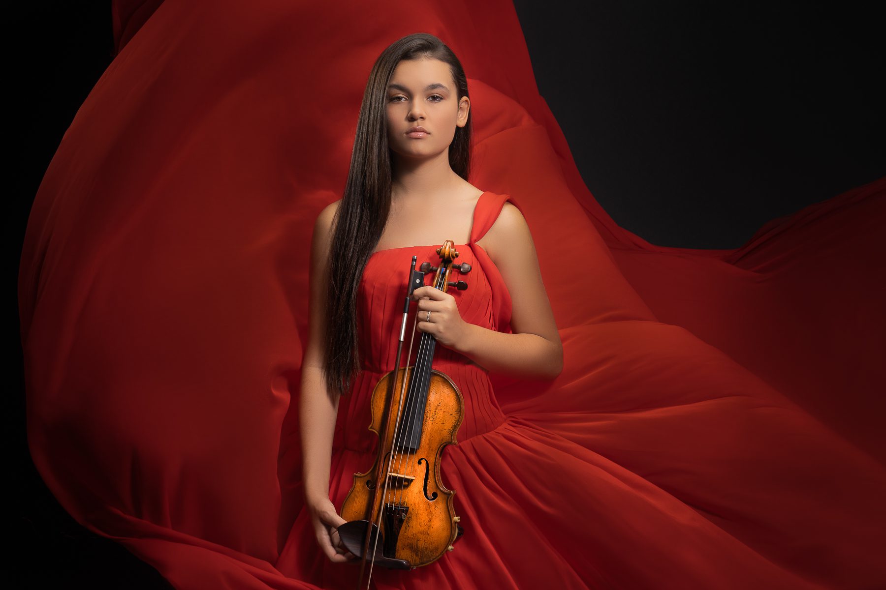 creative photoshoot with female violinist in red dress with violin