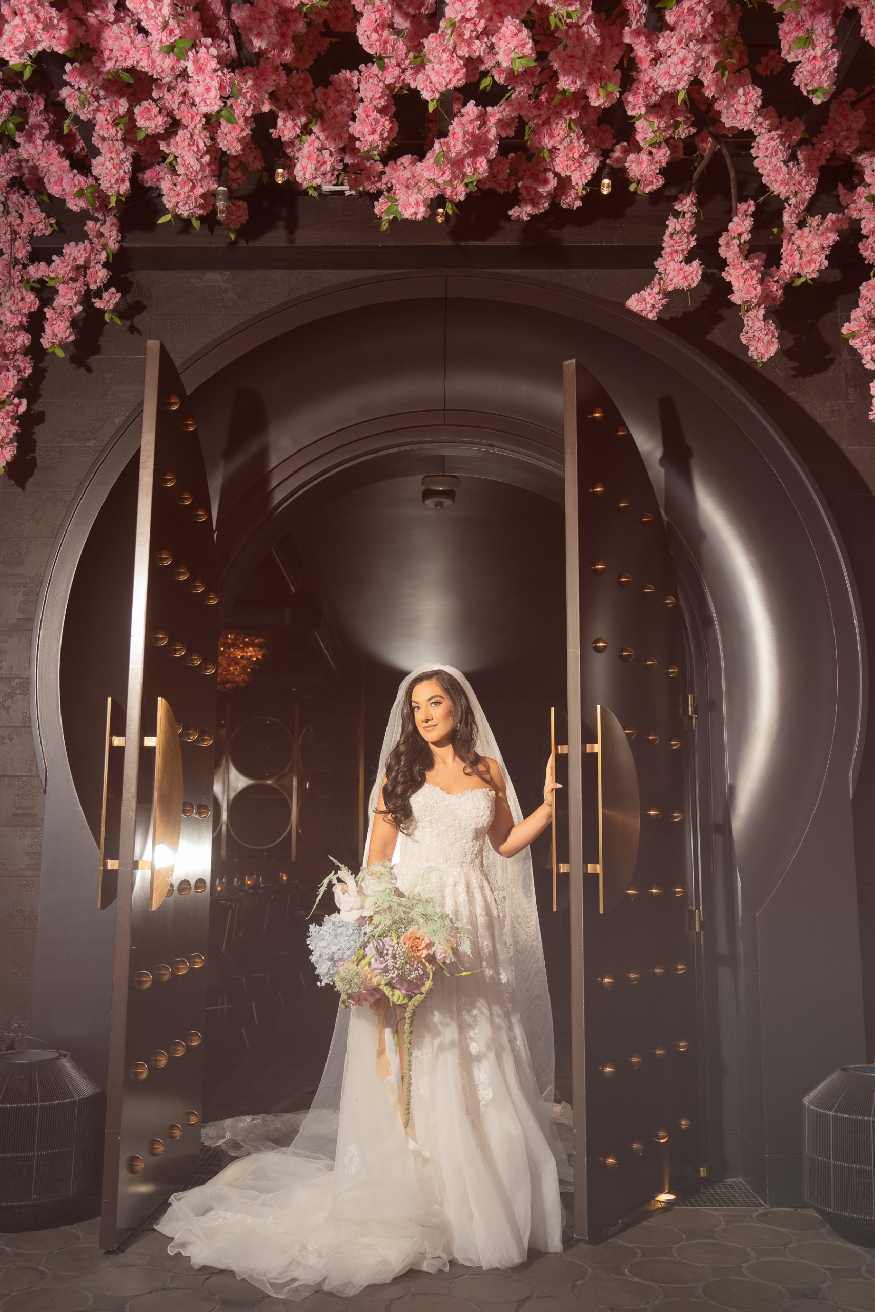 bride at Resorts World Las Vegas with Pink Flowers above her