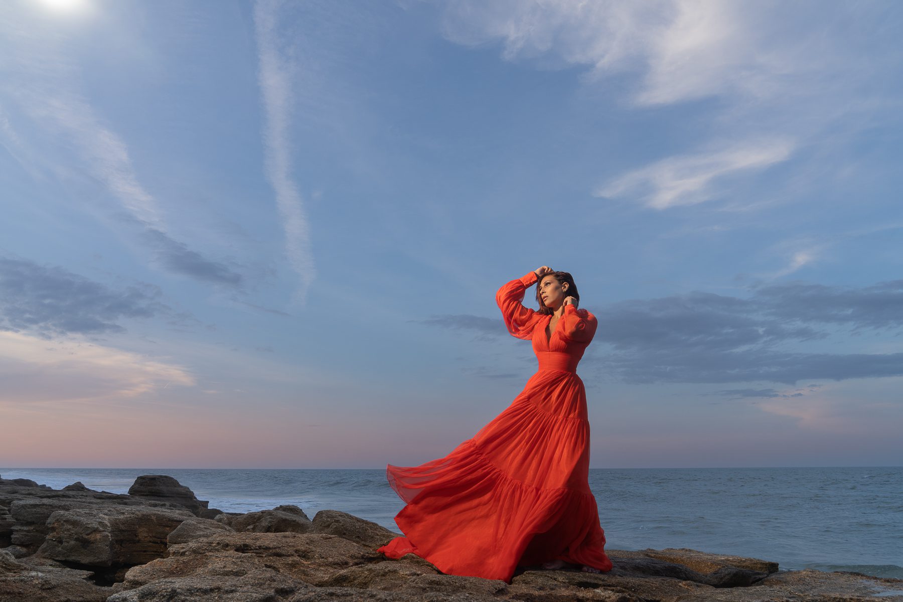 Strong woman in red dress on stones 2