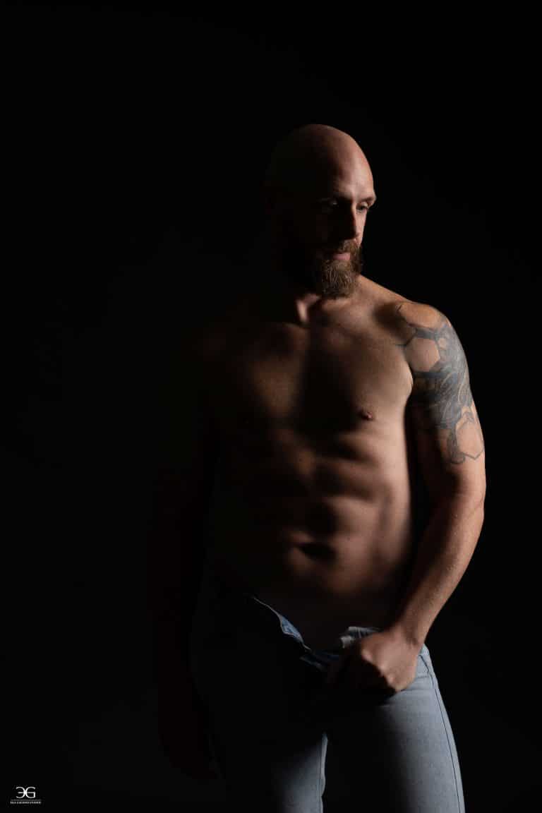 ramatic men's fitness portrait using studio lighting to highlight muscle definition