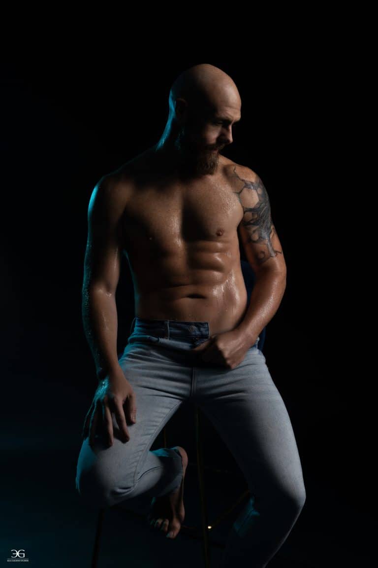 Men's portrait photography using dramatic lighting to highlight an athletic physique