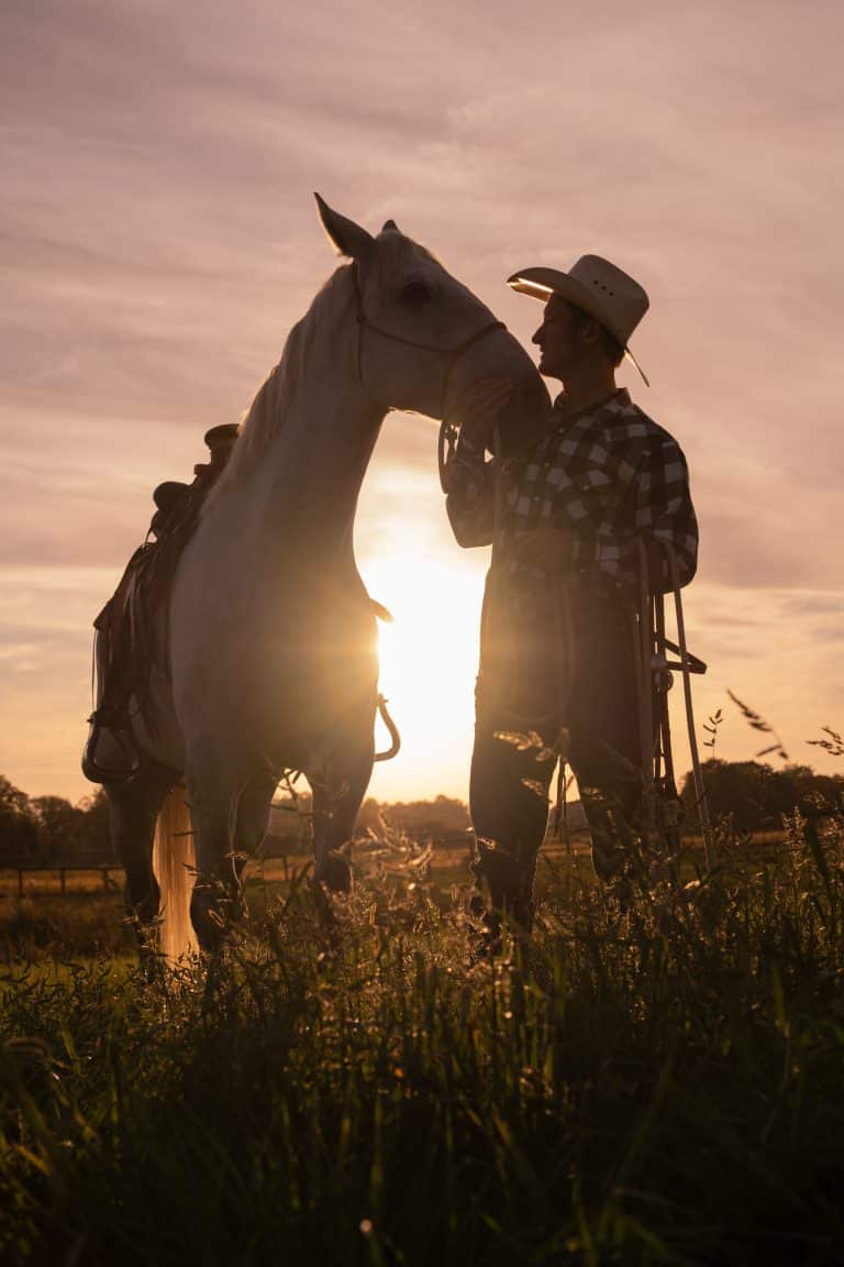 Horse trainer sharing a quiet moment with a horse at sunset in Kentucky
