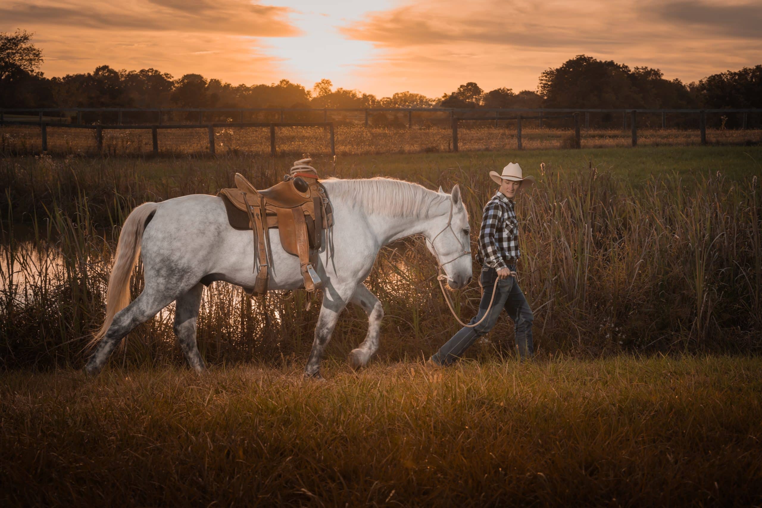 Horse trainer working with a white horse in a Kentucky field