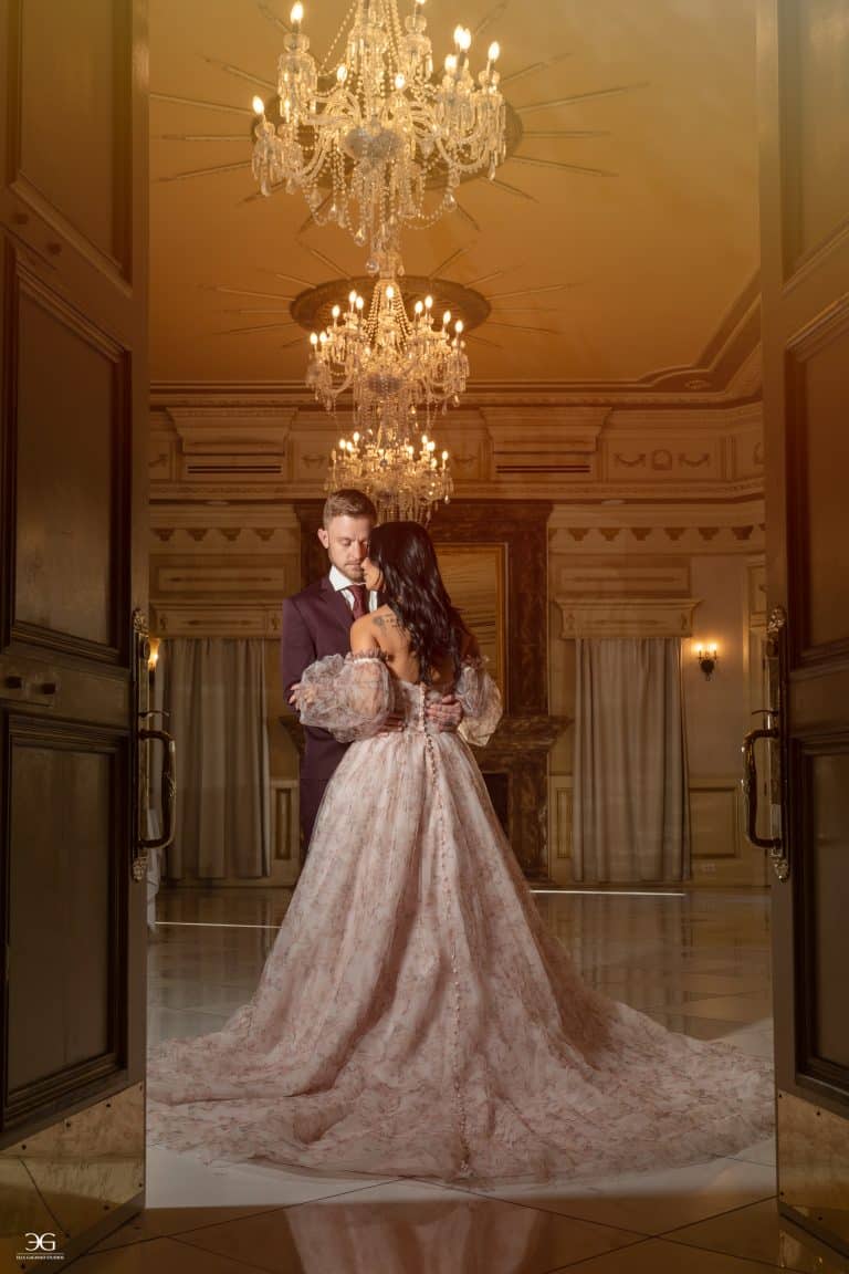 Couple embracing beneath crystal chandeliers inside The Kentucky Castle in Versailles, Kentucky