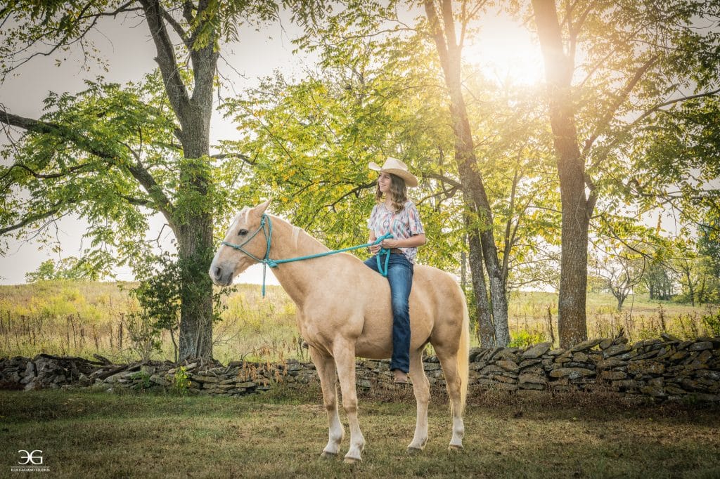Teen equestrian riding a horse beneath the trees on a Kentucky farm